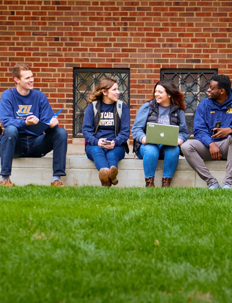 four JCU students sitting of a curb