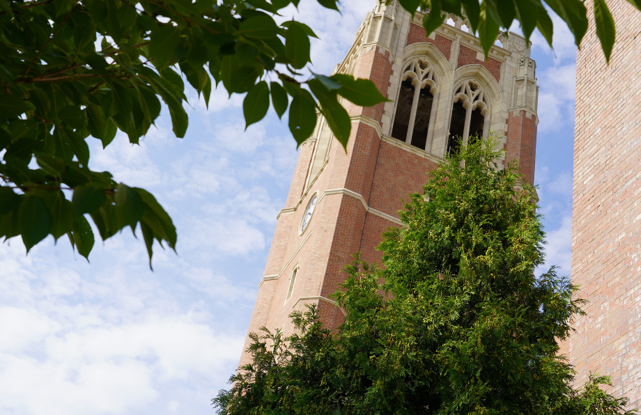 JCU clock tower behind some green trees on campus