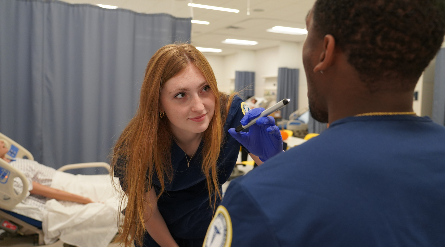 BSN student performing throat culture on another student