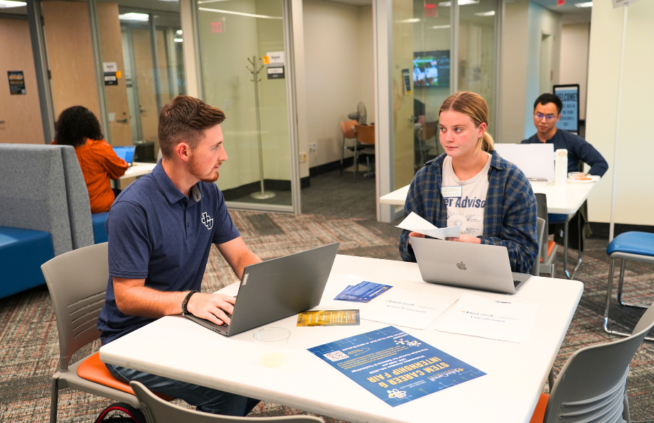 A Male and Female student working together in the student success commons