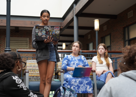 young writer reading her work to a group of peers