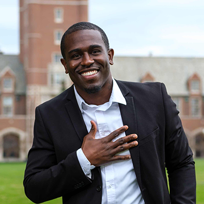 Picture of Michael Hollins, Sports Leadership Alum in suit outside St. Ignatius Hall