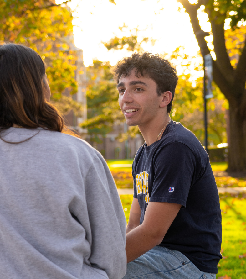 students talking by a residence hall on campus