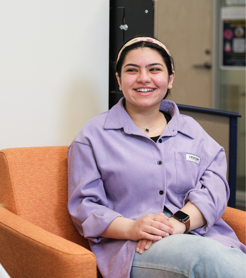 student sitting in a chair smiling