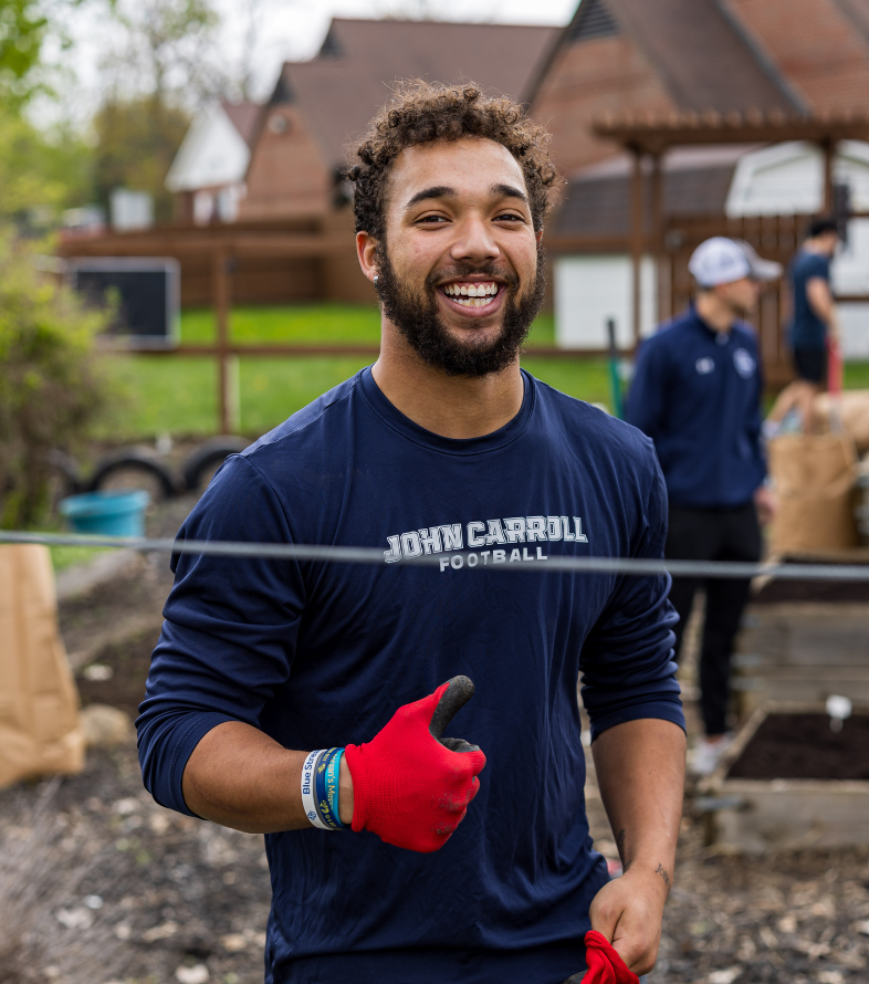 male student giving thumbs up on jesuit day of service