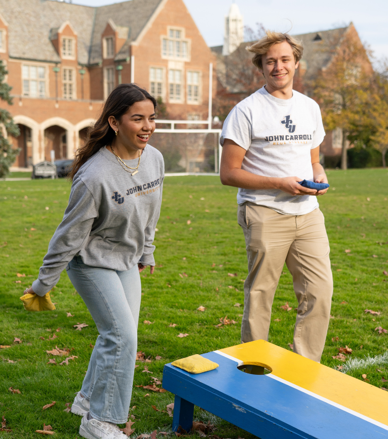 students playing cornhole on the campus quad