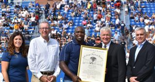 London Fletcher poses with JCU and NFF representatives at midfield.