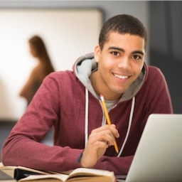 Picture of a male JCU student sitting in front of a laptop