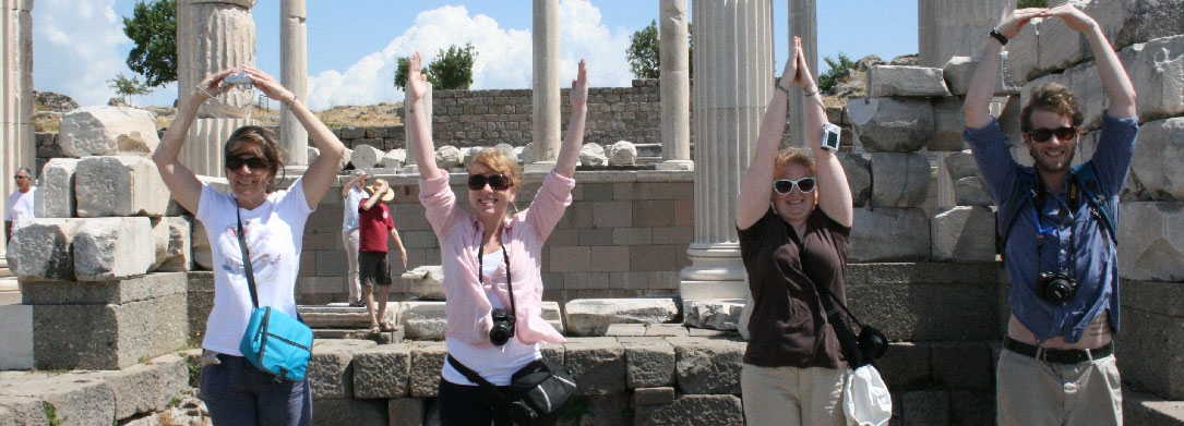 four people in front of ancient ruins