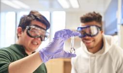 two students with goggles and test tubes