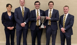 John Carroll CFA Challenge team members hold a trophy after winning their local competition.