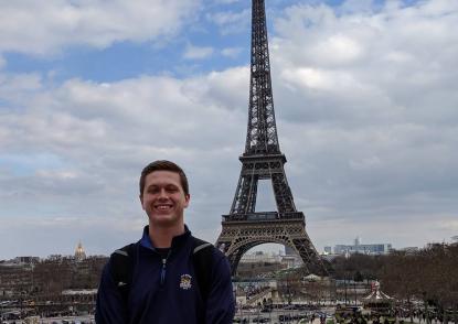 JCU student stands in front of the Eiffel Tower in Paris.