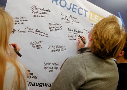 High School Juniors sign their name on a board at the Project Lead Summit