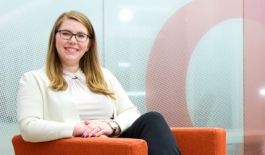 female student sitting in an orange chair and smiling