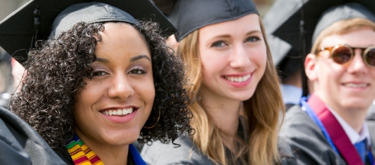Banner image of students wearing graduation caps and smiling