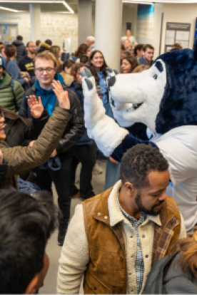 Lobo the Wolf high-fiving a student in the crowd at his release event.